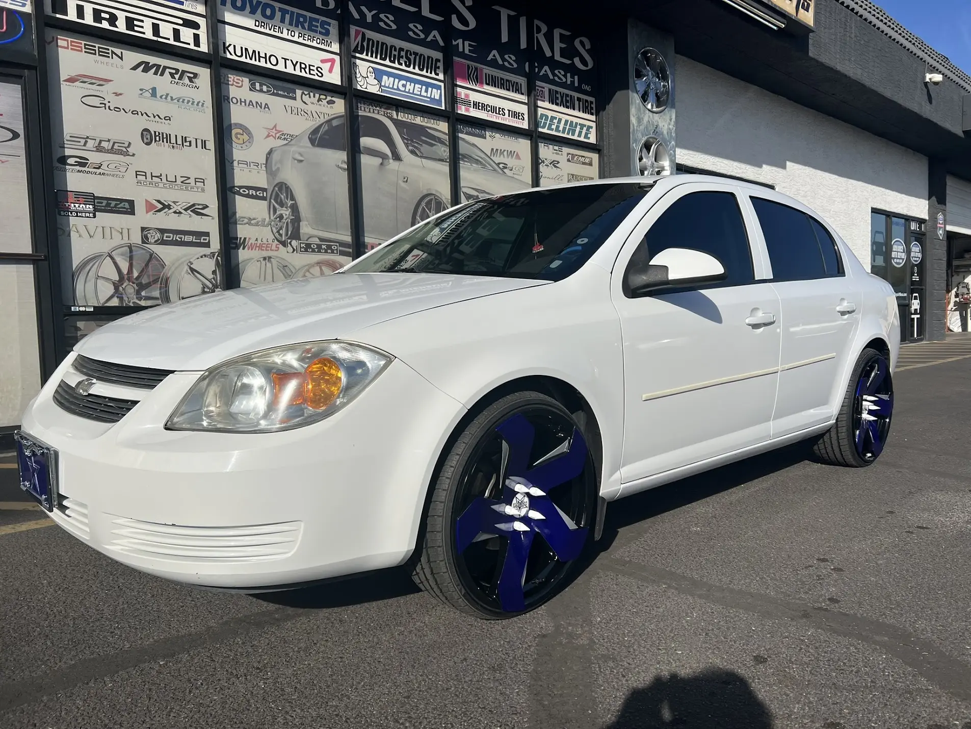 2007 Chevrolet Cobalt on 20x8.5 Strada Coltello wheels in custom Cowboys blue and silver with 225/30R20 tires