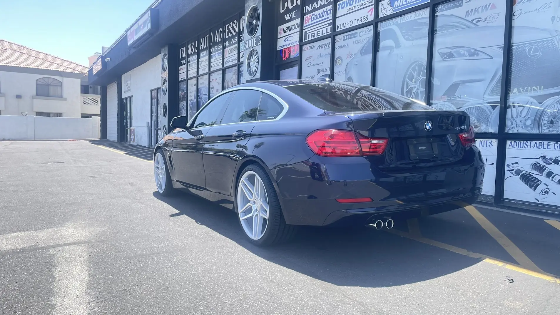 Blue BMW on 20-inch staggered custom wheels — rear view