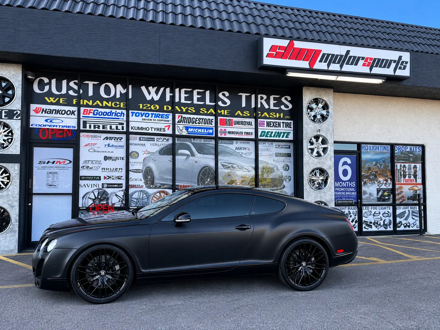 Full side view of the 2011 Bentley Continental GT in front of SHM Motorsports with matte black wrap and 22-inch staggered wheels