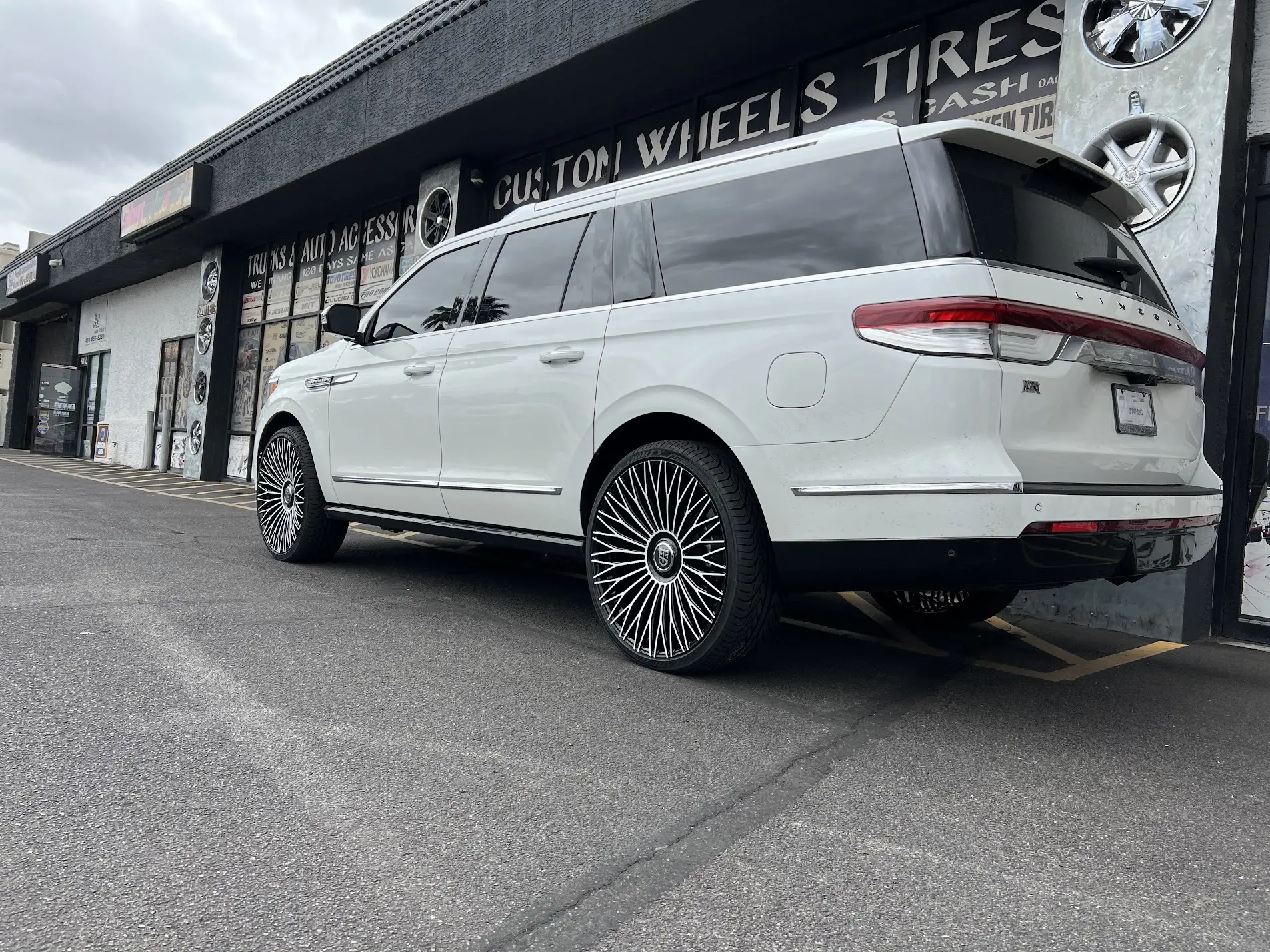 White Lincoln Navigator on large custom spoke wheels at SHM Motorsports