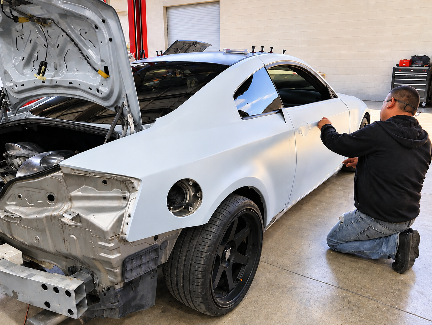 2005 Infiniti G35 coupe during a complete 3M matte white vinyl wrap with custom black wheels
