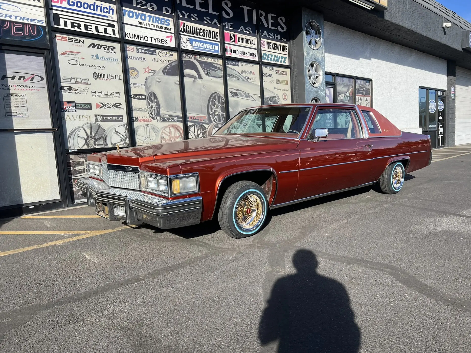 1979 Cadillac DeVille on 13x7 100-spoke wire wheels with 24-karat-gold centers, red Cadillac emblems and 155/80R13 whitewall tires
