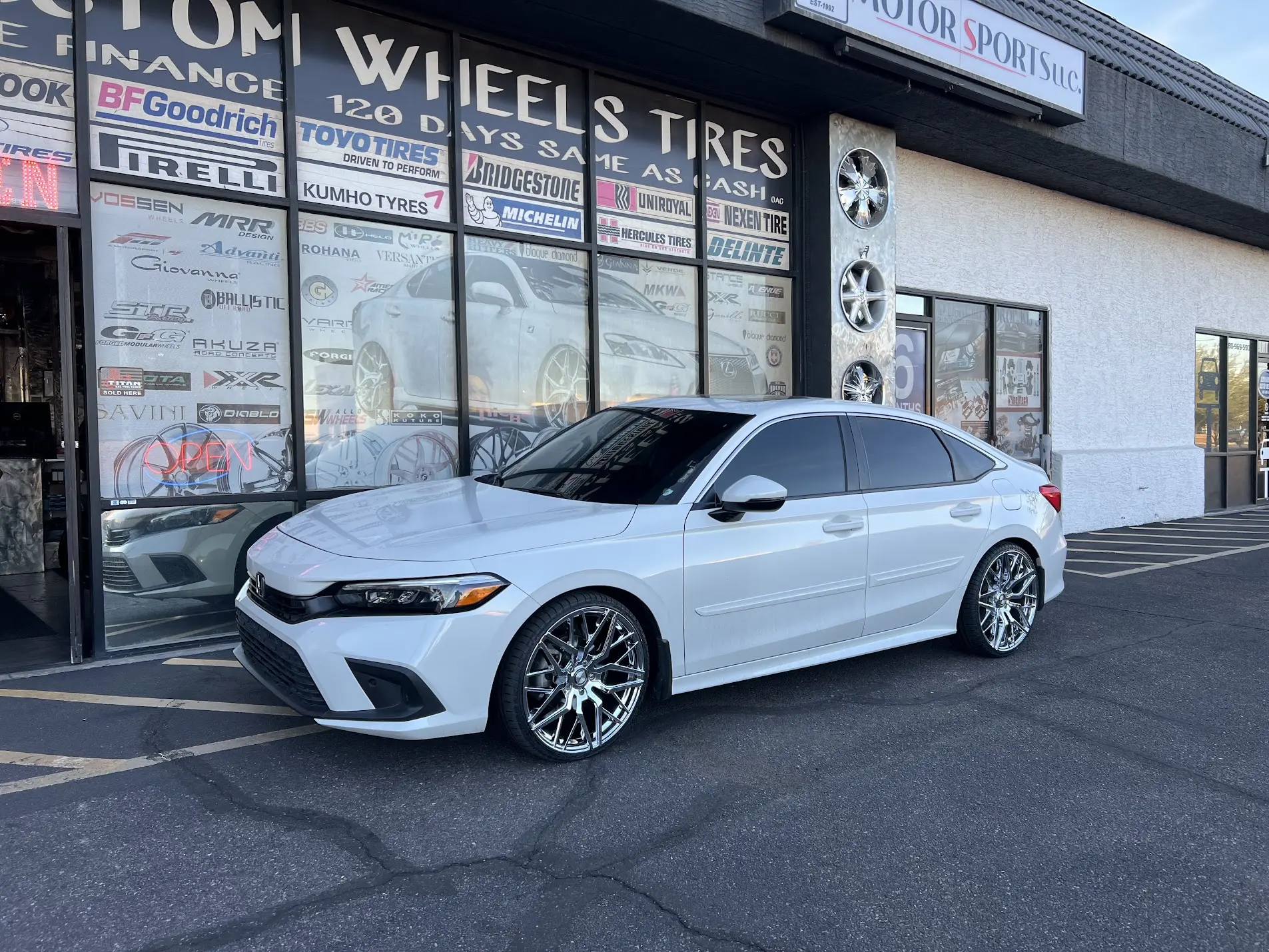 White sedan on 20-inch wheels with low-profile tires