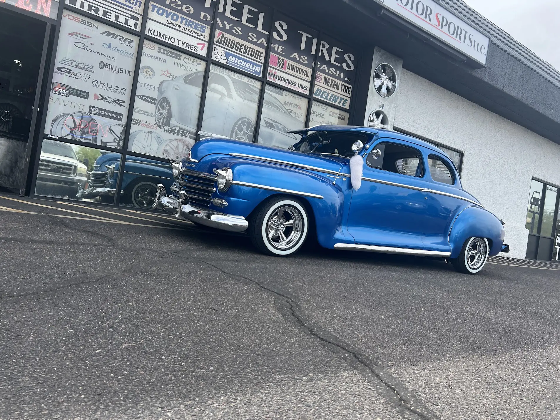 Blue classic Plymouth coupe on chrome wheels and whitewall tires at SHM Motorsports