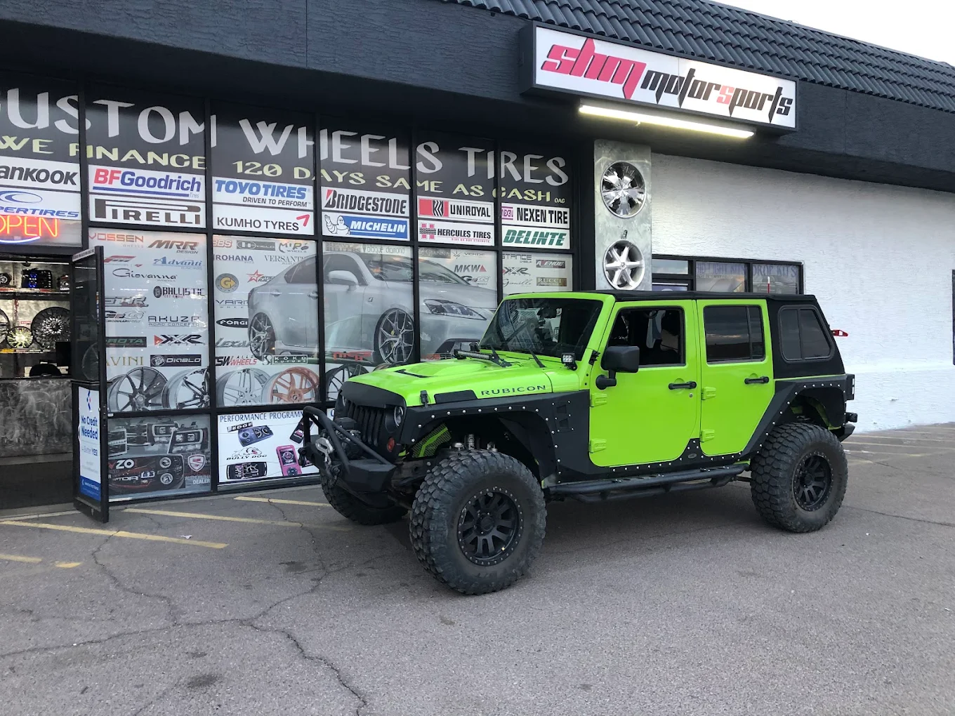 Lifted green Jeep Wrangler Rubicon on off-road wheels and tires at SHM Motorsports