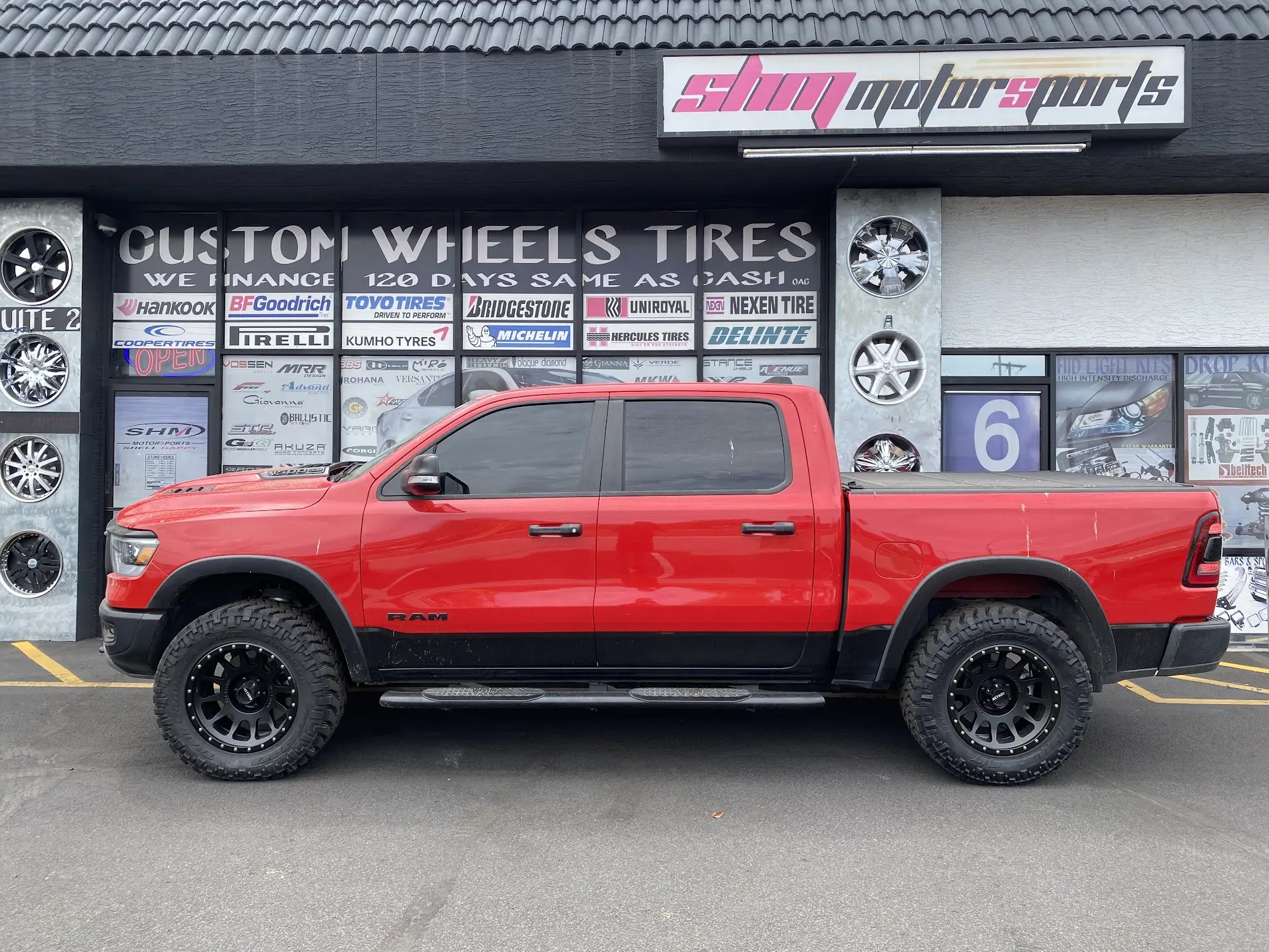 Red 2024 Ram 1500 Crew Cab 4x4 on Moto Metal 709-HD matte black wheels with Nitto Terra Grappler all-terrain tires at SHM Motorsports