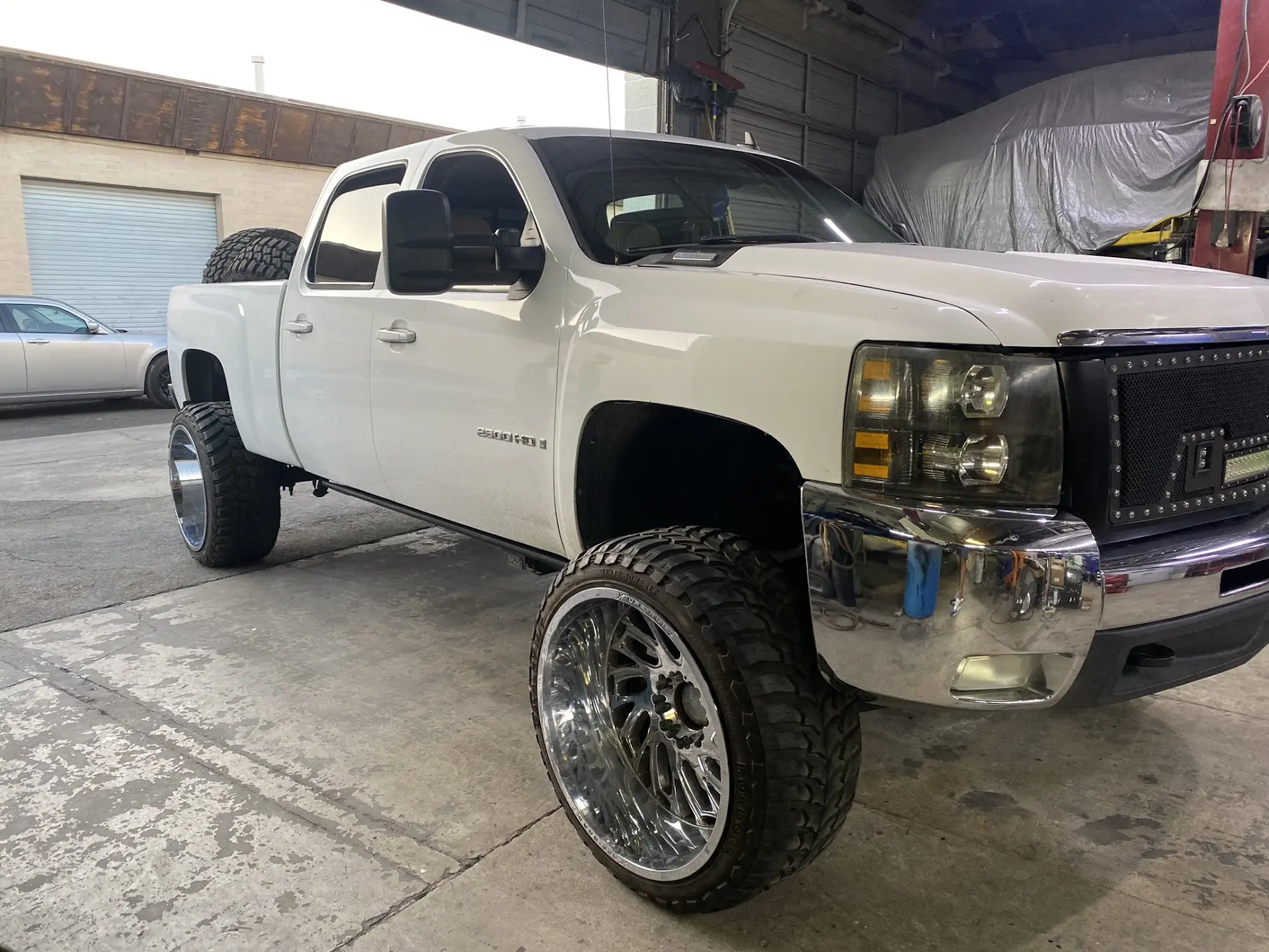White Chevrolet Silverado 2500HD 4x4 on 26x14 American Force wheels with 35x12.50R26 tires