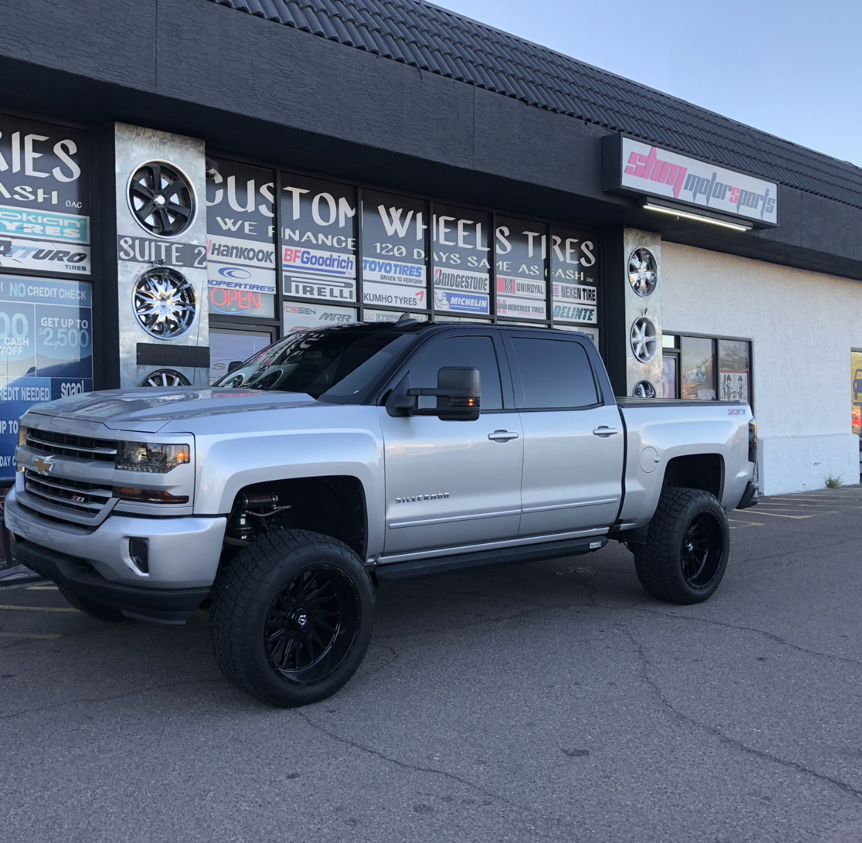 Silver Chevrolet Silverado 1500 Z71 on 24x12 gloss black AXE Wheels with 35x12.50R24 Toyo all-terrain tires at SHM Motorsports