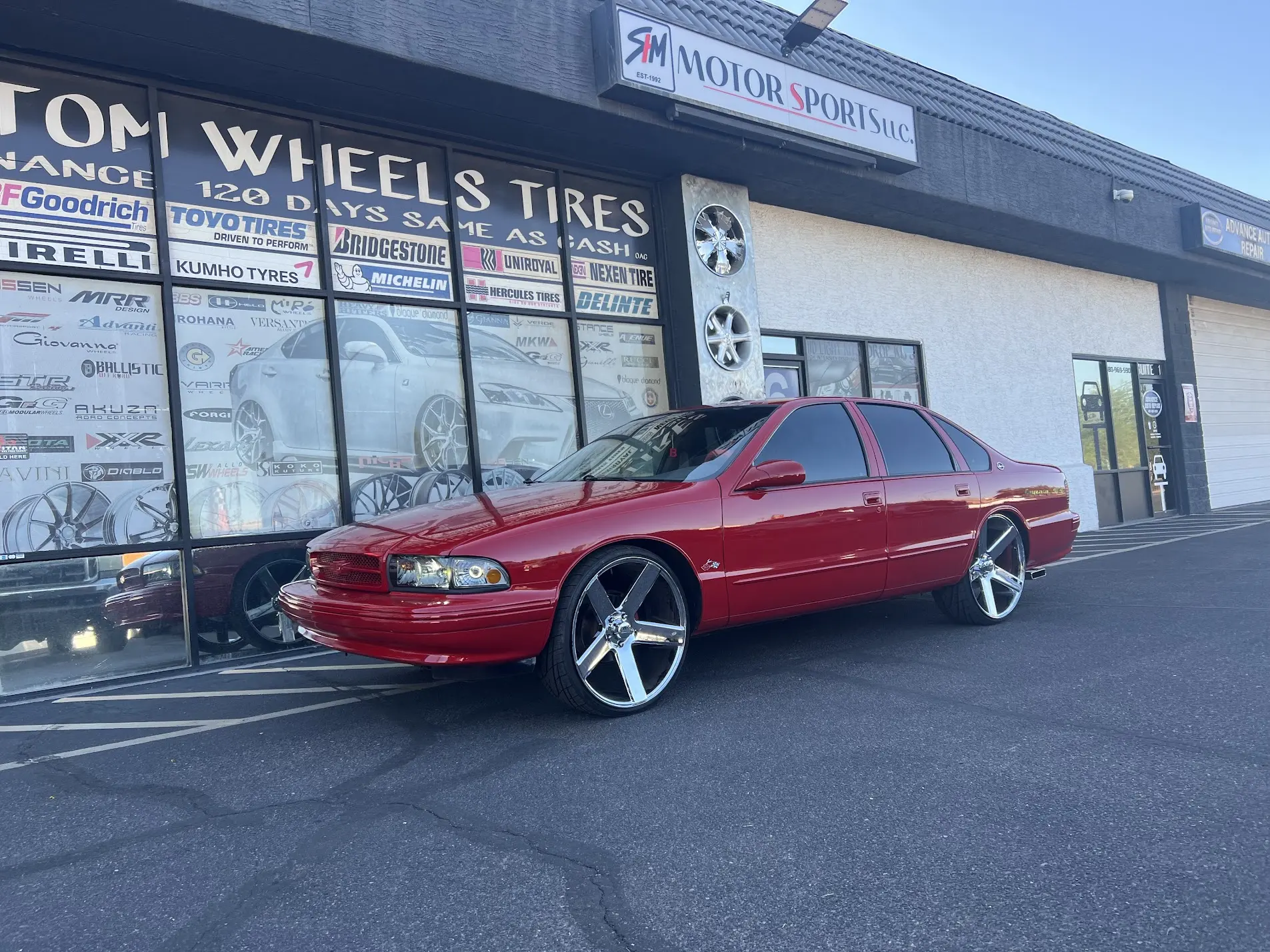 Red sedan on 24-inch custom wheels